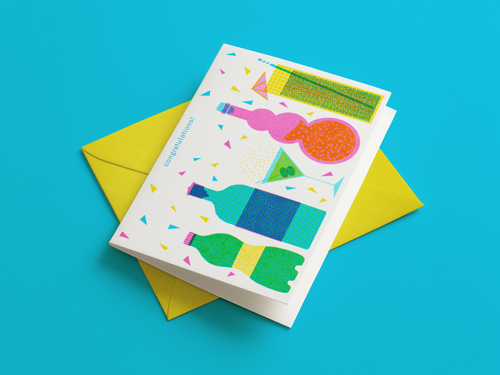 Colorful greeting card with bottle and balloon design on a yellow envelope against a blue background