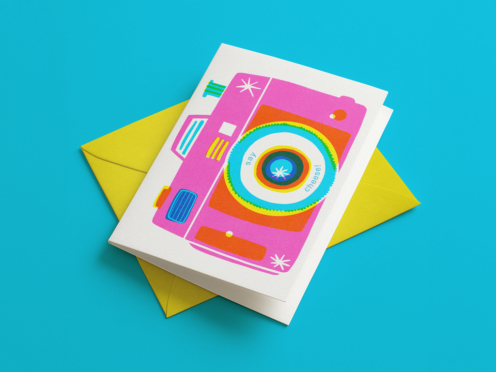 Colorful camera-themed card on a yellow envelope with a blue background