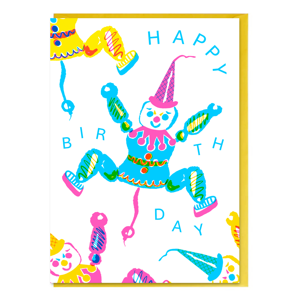 Colorful birthday card with a vintage toy clown puppet on string illustration and 'Happy Birthday' text, with canary yellow envelope.